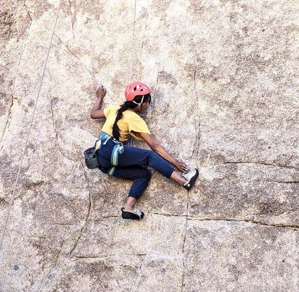 Women climbing rock wall