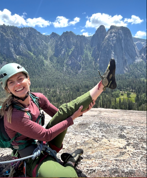 Women rock climber siting atop a climb in Yosemite.