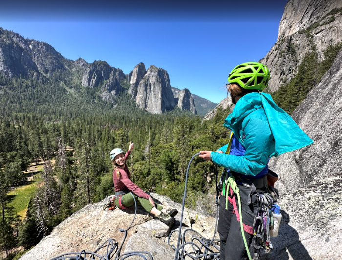 Women rock climber siting atop a climb in Yosemite.
