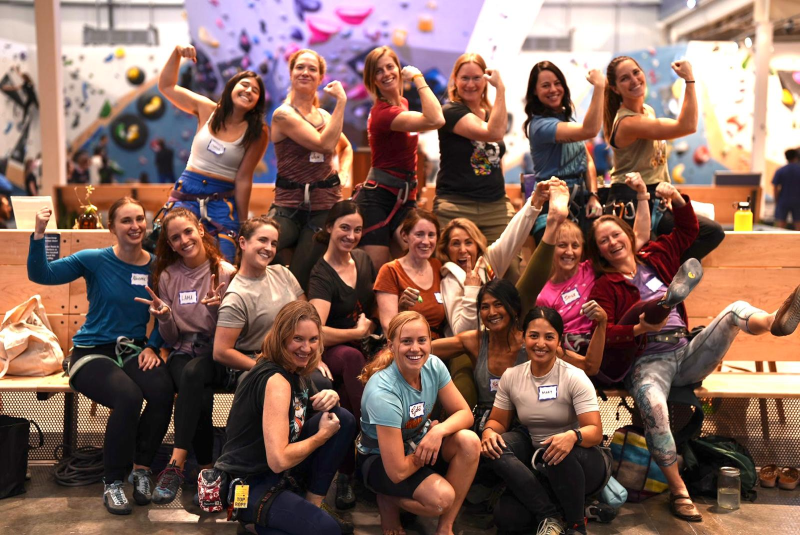 Group portrait of women at indoor rock climbing gym.