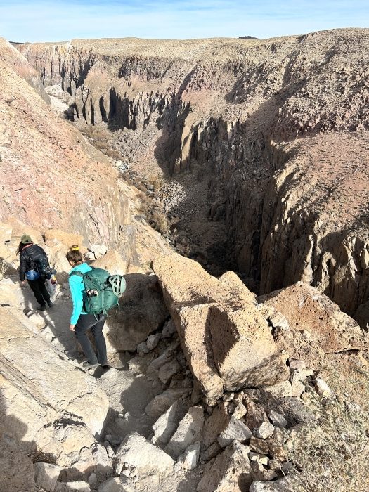 Women mountaineers hiking on edge of mountain.