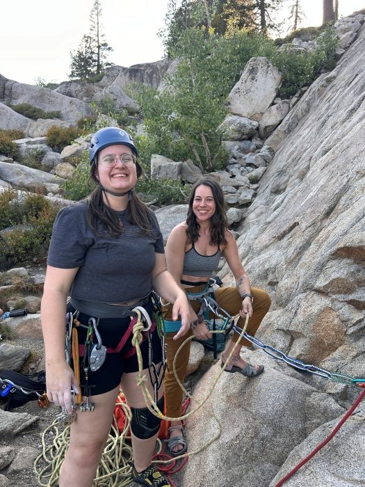 Rock climbers at base of rock wall ready to climb.