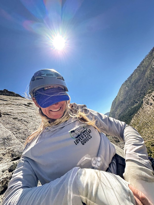 Woman gearing up for an outdoor rock climb.