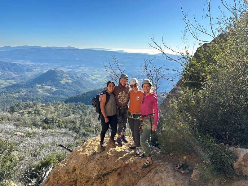 Four Women's Lead Club members posing for a portrait at the crag.