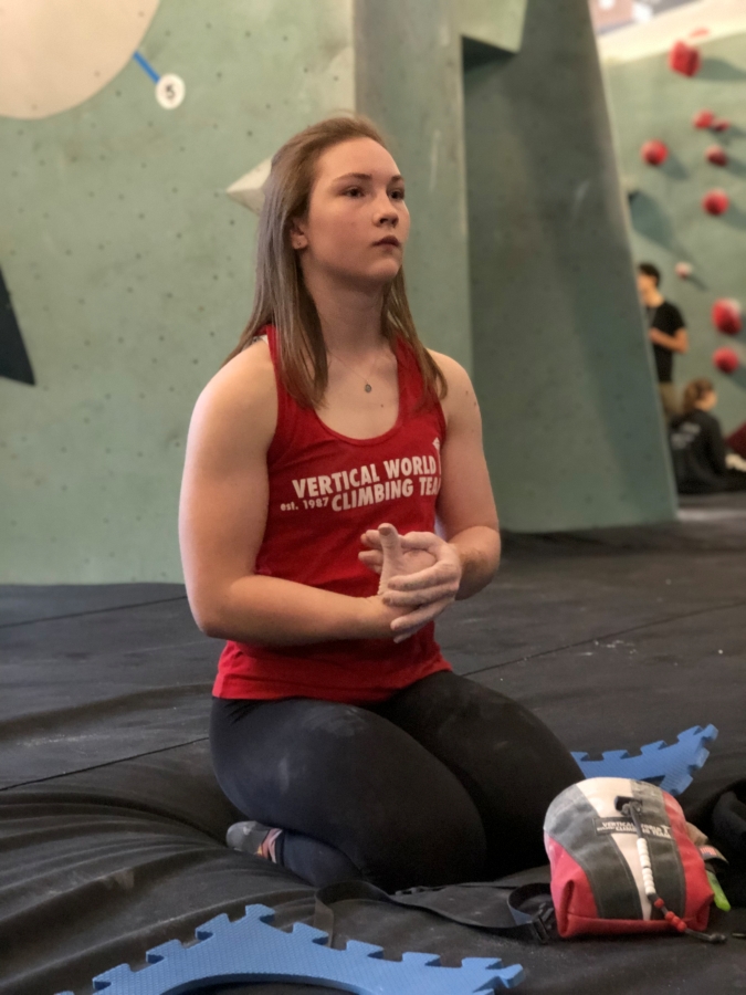 Woman rock climber reviewing climb at climbing competition.