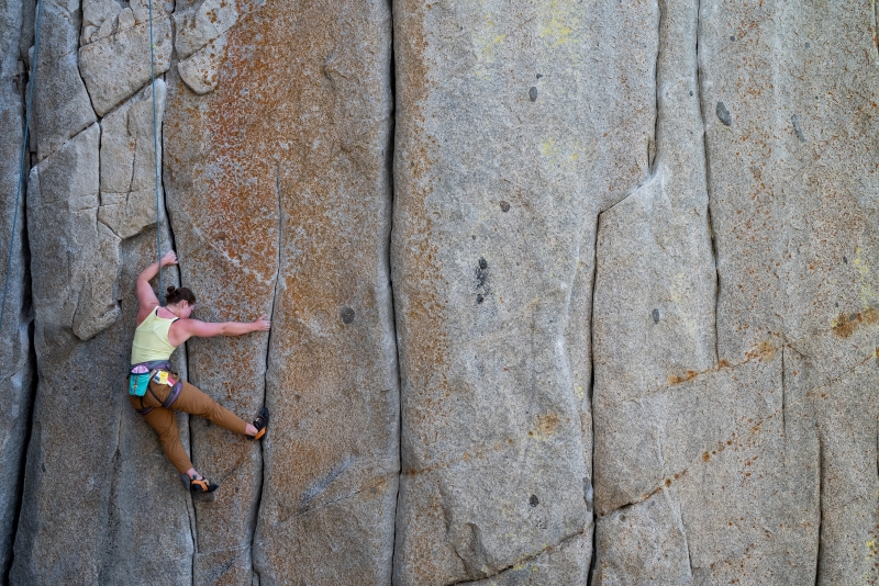 Rock climber completing a hard move in a crack on outdoor rock climb.