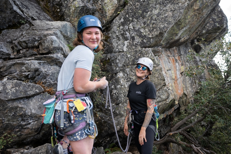Women rock climbers getting ready for a climb outside.