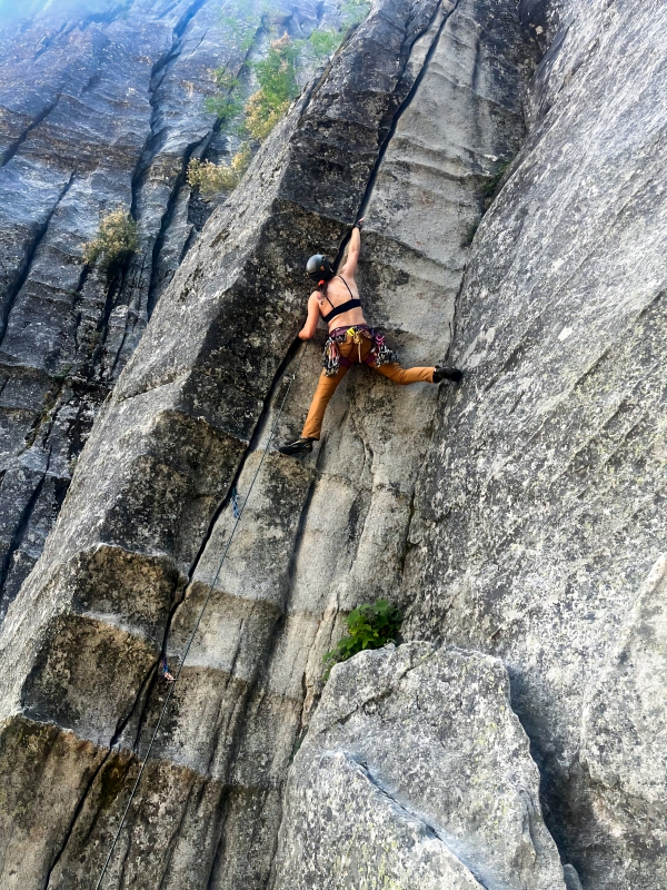 Rock climber ascending granite rock face and crack.