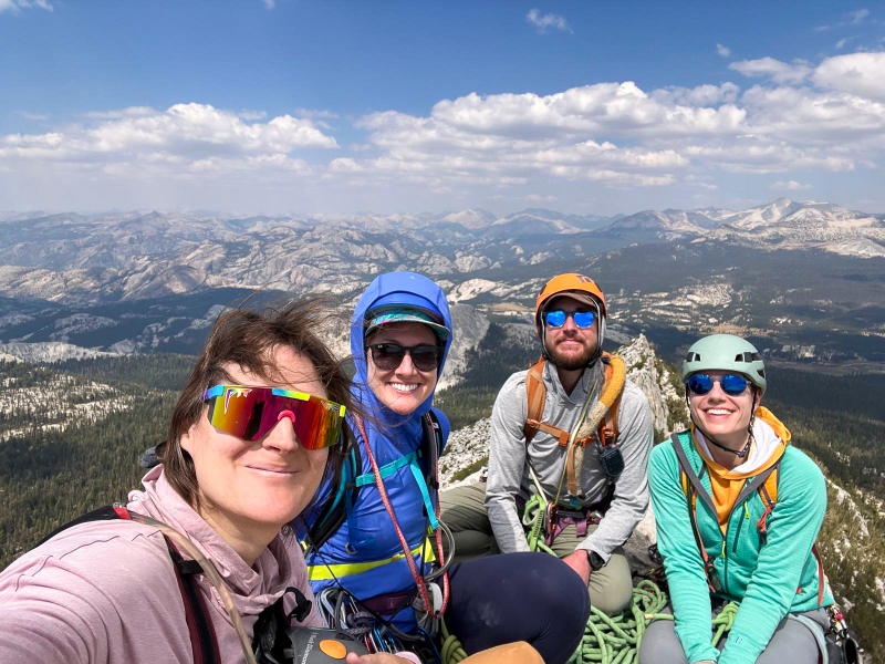 Group portrait of rock climbing friends atop peak.