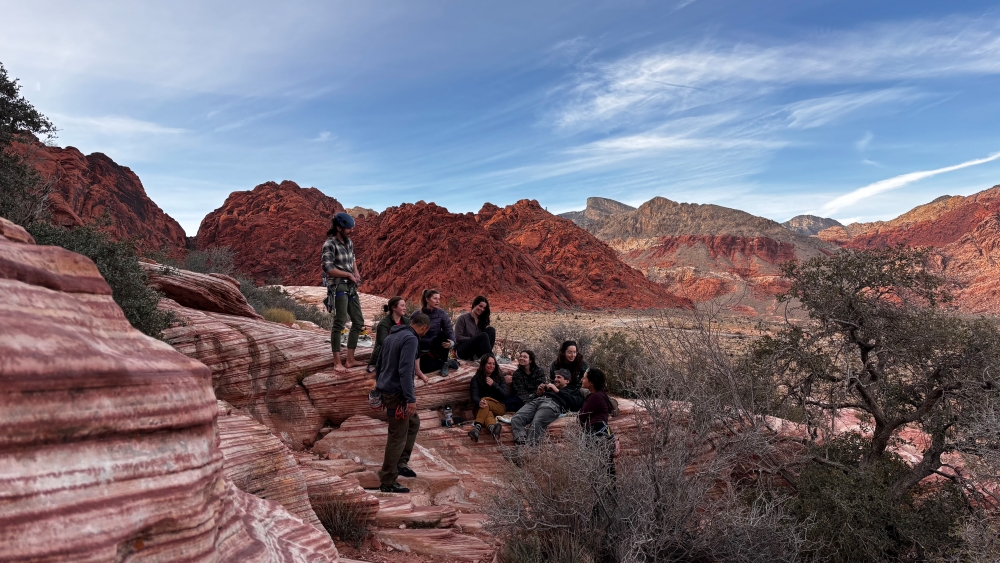 Group of rock climbers sitting around talking at Red Rocks crag.