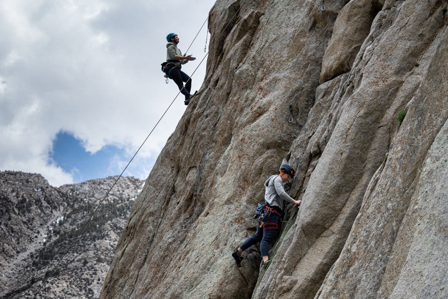 Women rock climbing on granite rock wall at Pine Creek Canyon.